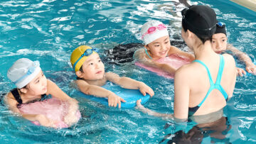 水泳コーチが子どもを指導する様子